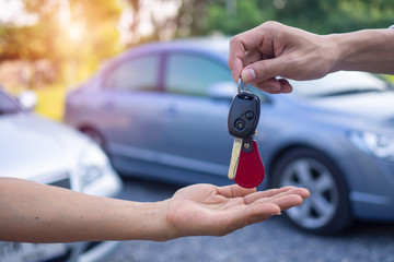 The car salesman and the key to the new owner.