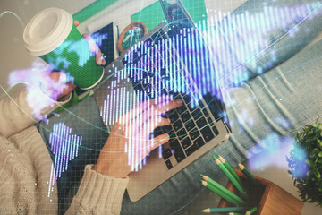 Double exposure of woman hands typing on computer and business theme hologram drawing. Success...