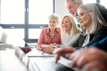 Group of senior people attending computer and technology education class.