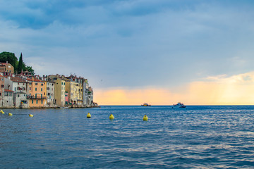 View of the horizon over the Adriatic Sea, with the typical croatian old houses in the coastline of the old town of Rovinj, Croatia, during the sunset