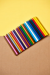 multi-colored pencils on a yellow and brown cardboard