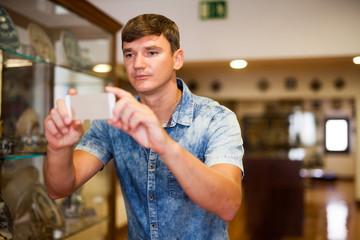 Man taking pictures on phone inmuseum