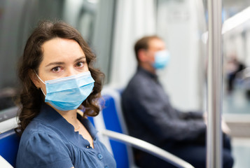 Fototapeta na wymiar Brunette in medical mask in subway car