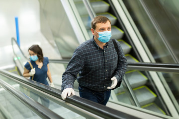 People in protective masks on the escalator