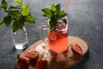 Fresh strawberry lemonade with ice and mint in glass. Cold summer drink. Sparkling glass with berry cocktail.Strawberry mojito . Cold refreshing cocktail