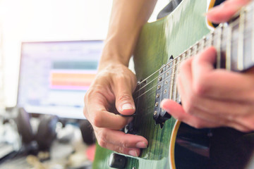 musician recording eclectric guitar in studio