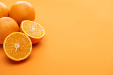 ripe delicious cut and whole oranges on colorful background