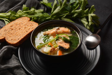 Fresh fish soup on black background