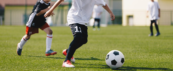 Obraz premium Junior soccer players on a game. European football tournament match between young footballers