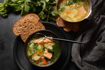 Fresh fish soup on black background