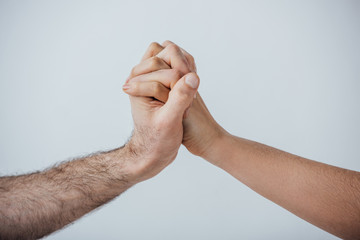 Cropped view of men holding hands isolated on grey