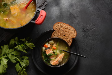 Fresh fish soup on black background
