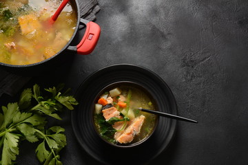 Fresh fish soup on black background