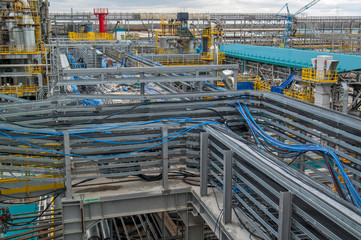 Type of metal structures of a large plant, overpasses, communications, cranes, pipes. Large-scale view from a height.