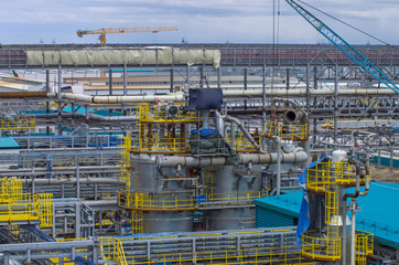 Type of metal structures of a large plant, overpasses, communications, cranes, pipes. Large-scale view from a height.