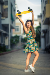 Fototapeta premium Portrait of a beautiful woman with skateboard