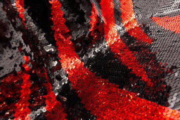 Texture of red and black sequins on a modern, elegant, evening dress. The concept of a glamorous...