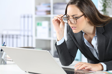 Executive with eyeglasses having eyesight problems at office