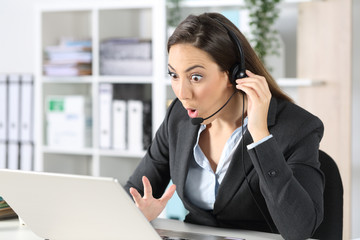 Surprised telemarketer reading news on laptop at office