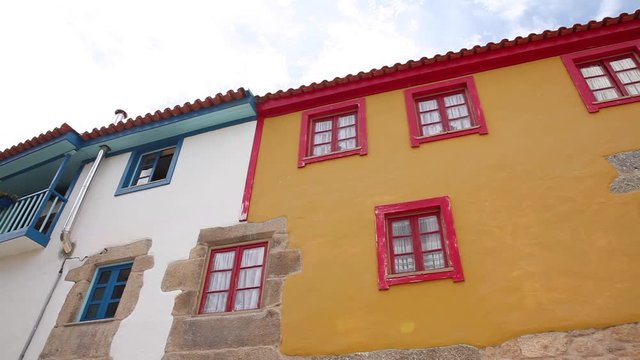 Tradicional rural house facade with yellow with red windows and white with.green windows facade Ucanha in Portugal