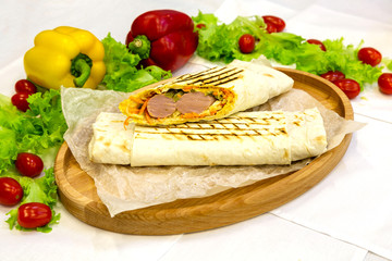 Shawarma, meat kebab on a plate with vegetables, traditional meat food in pita bread