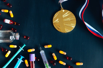 Gold medal and drugs, syringe and Medicine bottle for injection. Doping in sport, black edit space