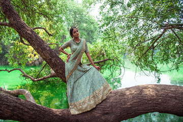 ull length portrait of an young beautiful Indian female model in traditional green designer dress...
