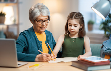 Girl studying with grandma.