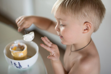 Little boy eats a spoon of ice cream