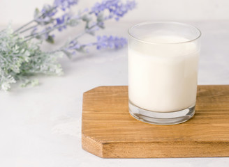 Fermented kefir drink in a glass on a wooden board on a white background. Rustic