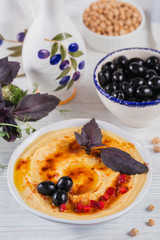 Healthy breakfast with homemade hummus and black olives on white wooden background. Diet and Healthy snack food