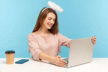 Lovely angelic kind woman with nimbus outstretching hands and embracing laptop screen, sharing free...