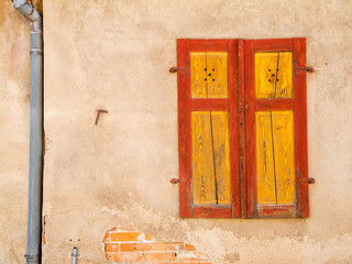 Red yellow shutter on house wall