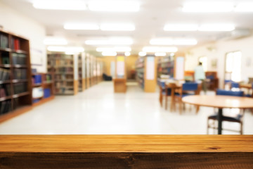 Empty wooden desk space platform with library background for product display montage. Education concept.