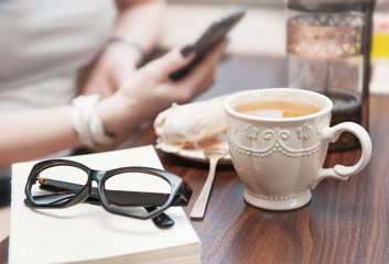Cup of tea and eyeglasses on book on the table. Cozy home concept