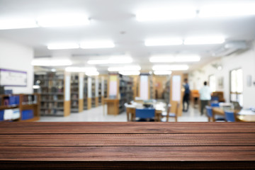 Fototapeta premium Empty wooden desk space platform with library background for product display montage. Education concept.
