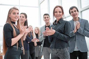young employees applauding together standing in the office .