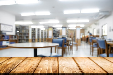 Empty wooden desk space platform with library background for product display montage. Education concept.