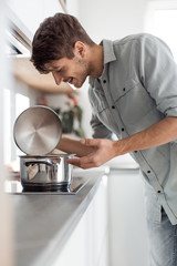 smiling young employee sitting at his Desk and pointing at you