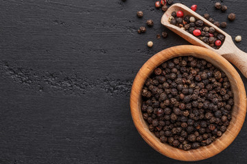 A set of peppers.Collage of different type pepper, Black ,white, pink and allspice peppercornsr, dried chili pepper.Top view. On a black background. free space for your text.