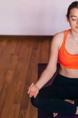 Cropped image of a young woman sits in a lotus pose and meditati