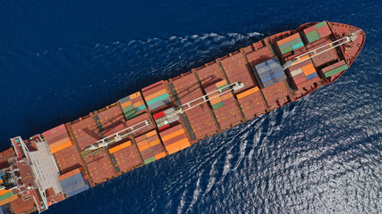 Aerial drone photo of huge colourful truck size container cargo ship cruising open ocean sea