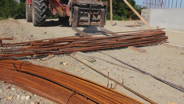 Telescopic forklift that until he raise pile of rusty reinforcing steel, armature stacked temporarily.