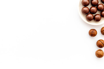 Chocolate candy balls on white background top view copy space