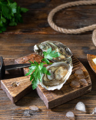 Two oysters on a wooden Board against the background of a basket of oysters. Original restaurant serving of oysters. Rustic style. French cuisine