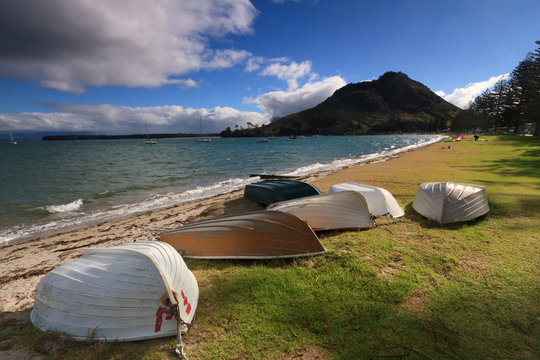 Rowboats on the beach at Pilot Bay, Mount Maunganui, New Zealand, with "the Mount" in the background