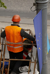 Workers in reflective vests hang the flag of Europe on a pole
Europe day
