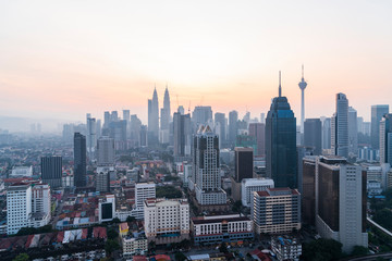 Naklejka premium Panoramic view of Kuala Lumpur skyline at sunset. City center of capital of Malaysia. Contemporary buildings exterior with glass.