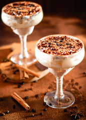 italian dessert tiramisu in an elegant cocktail glass, the concept of sweet life, luxury, delicious food