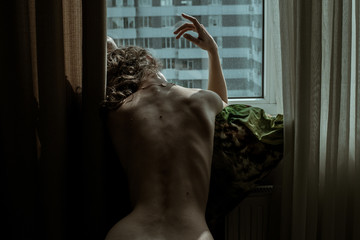 Naked woman relax by window, Elegant hand. Stay isolation at home. Sensual beautiful naturally look girl back skin with moles. Sexy nude body background. Slim waist. Portrait sexy female fit figure